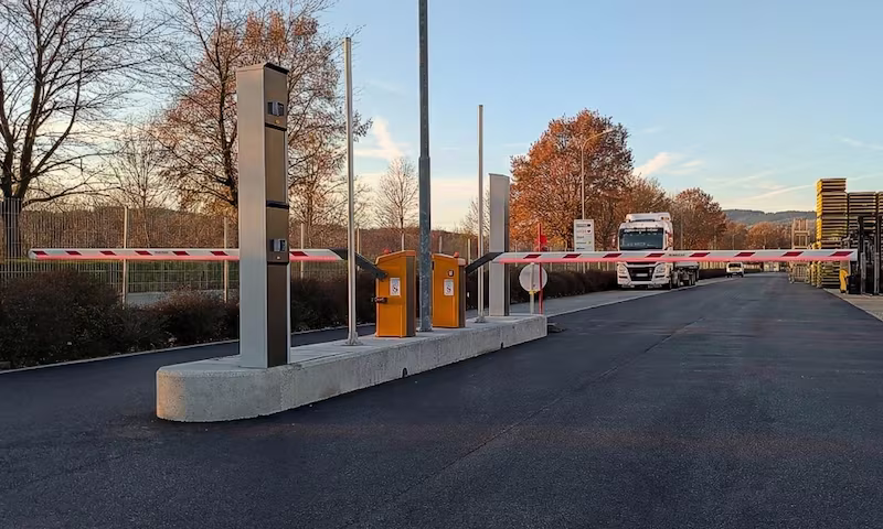 Einwandfreie Ausführung einer LKW-Zufahrt. Durch die erhöhte Verkehrsinsel wird das Risiko für Anfahrschäden minimiert und die Schrankenbäume rücken besser in das Sichtfeld der Fahrer. Die Fahrbahn ist sehr breit und die LED-Beleuchtung sorgt auch bei Dämmerung für eine gute Erkennbarkeit der Schrankenbäume.